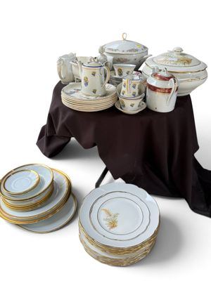 many plates and cups on a table with a black table cloth