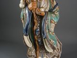 statue d'un homme barbu vêtu d'une robe bleue et tenant un oiseau