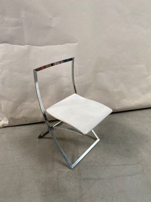 a white chair that is next to a white wall