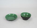 pair of green and black bowls on a white surface