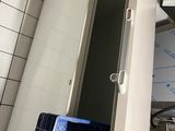 a refrigerator in the corner of a kitchen with a microwave on it
