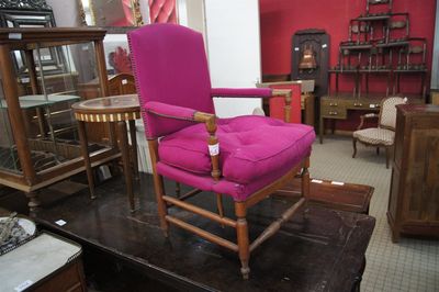 a pink chair that is sitting in a room