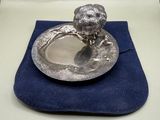 a silver plate on a blue cloth on a table