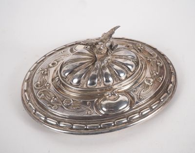 a silver plate with a bird on it on a white surface