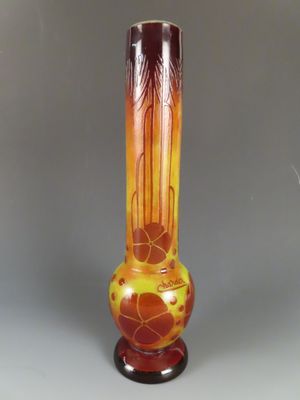 un vase orange posé sur un socle en bois