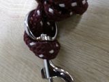 a close up of a red and white rope with a metal hook