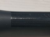 a close up of a black pen on a white surface