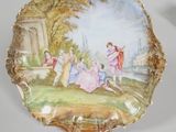 two plates with a painting on them sitting on top of a table