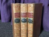 Deux livres sont posés sur une table recouverte d'un tissu violet.