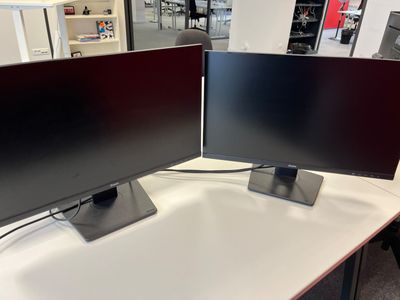 two monitors sitting on a table in a store