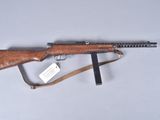 a rifle with a wooden barrel and a sling on a white surface