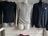several sweaters and jackets are on display in a clothing store