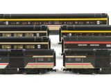 three black and yellow train cars sitting next to each other on a white surface