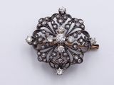 a close up of a diamond broochle on a white surface
