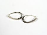une paire de boucles d'oreilles créoles en argent sur fond blanc