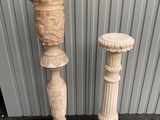 pair of carved stone pedestals on a black floor