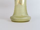 a green glass vase with a gold decoration on it