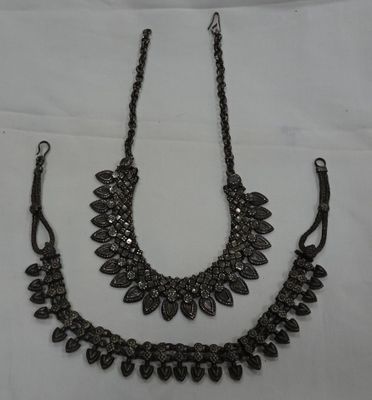 2 Colliers en métal à décor de feuilles et fleurs stylisées.