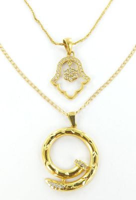 un collier en or orné d'une hamsa et d'un pendentif en diamant