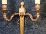 pair of antique brass candelabs with candles on a blue background