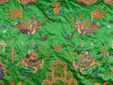 an image of a close up of a green fabric with colorful designs on it