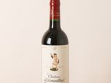 the bottle of red wine is sitting on a wooden table