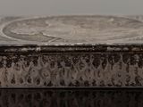 an old silver box sitting on top of a glass table