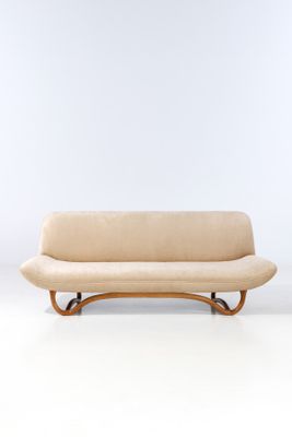 an image of a couch with a curved back and a wooden frame