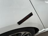 a close up of a white car with a sticker on it ' s side
