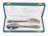 two forks and a spoon in a green box