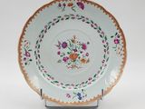 an image of a plate with flowers on it on a stand