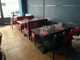 tables and chairs in a restaurant with blue walls and red chairs