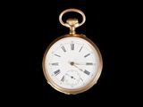 a gold pocket watch with roman numerals on the face