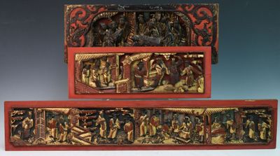 two wooden carvings of people and animals on display in a museum