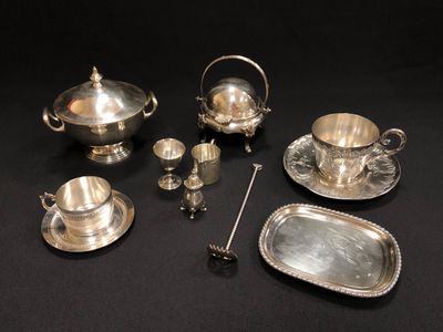 un assortiment d'objets plaqués argent sur un fond noir