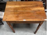 a small wooden table with a label on it