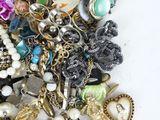 a pile of assorted jewelry on a white surface