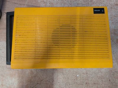 un radiateur jaune posé par terre à côté d'une paire de chaussures