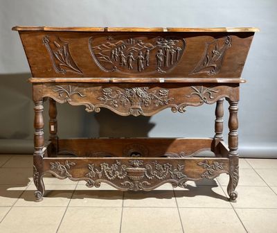 une vieille table en bois dont le plateau est orné de sculptures