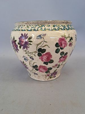 un vase blanc avec des fleurs roses sur une table