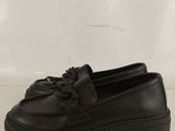 black leather loafers with tassels on the soles