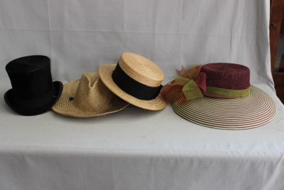 Plusieurs chapeaux sont alignés sur une table recouverte d'une nappe blanche