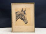 an old picture of a horse in a frame on a table
