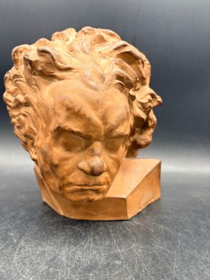 une image représentant une sculpture représentant une tête d'homme posée sur un livre