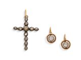 un gros plan d'une croix et d'une paire de boucles d'oreilles sur une surface blanche