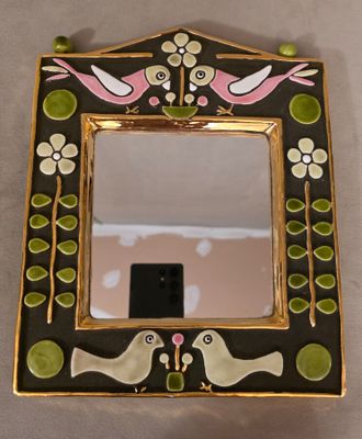 une photo d'un miroir sur lequel sont représentés deux oiseaux