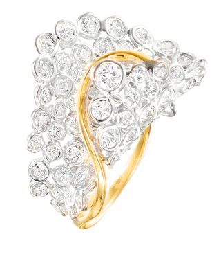 un gros plan d'une bague en diamant et en or sur fond blanc