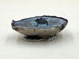 un bol en argent orné d'un oiseau sur un fond blanc