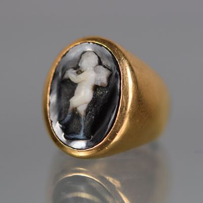 a close up of a gold ring with an image of a man and a woman