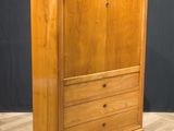 a wooden cabinet with a marble top on a wooden floor